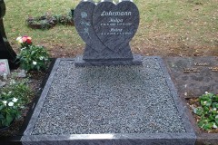 Lindenhorst, Urnendoppelgrab Grabstein mit Blume und Einfassung