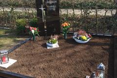 grabstein_schwarz_mit_graniteinfassung_und_edelstahlkreuz