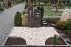 grabstein_zweiteilig_mit_gehauenem_ornament_und_kiesflaeche